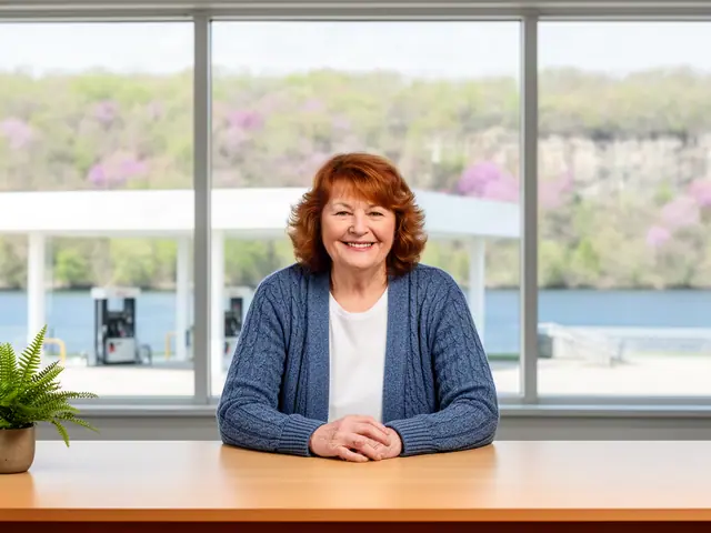 Convenience store owner leaning on her counter, fuel canopy and wooded river bluffs through the front windows